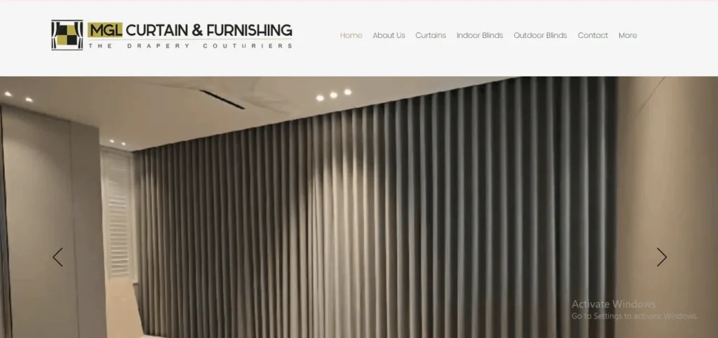 Website homepage screenshot of MGL Curtain & Furnishing, showcasing a large hero banner with full-length, floor-to-ceiling grey pleated curtains in a modern interior.