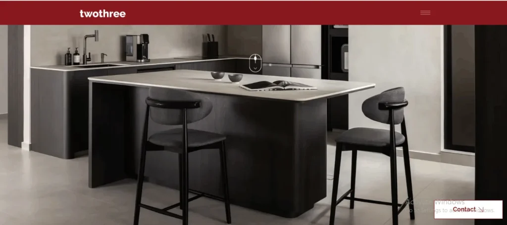 Modern dark wood kitchen island with gray barstools on the twothree website homepage.