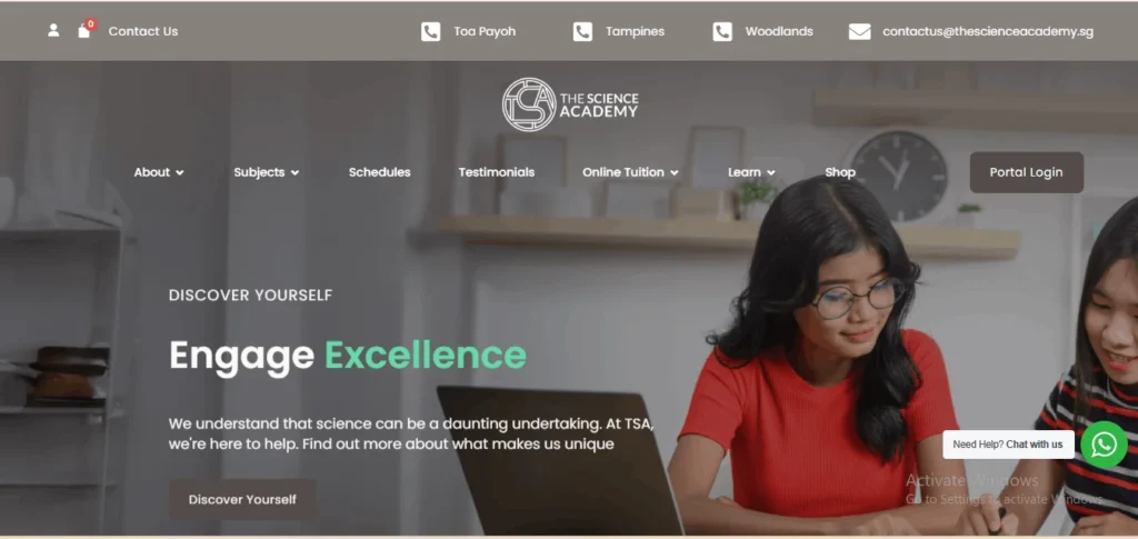 Website banner for The Science Academy (TSA) featuring two female students looking at a laptop and working together. The text reads, "DISCOVER YOURSELF | Engage Excellence," followed by a brief statement about helping students navigate science. The top navigation bar lists location branches in Toa Payoh, Tampines, and Woodlands, alongside a "Portal Login" button.