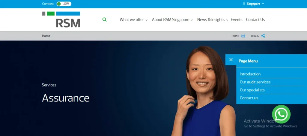 Screenshot of the RSM Singapore website's "Assurance" services page. The website header includes the RSM logo, a search icon, and main navigation links: What we offer, About RSM Singapore, News & Insights, Events, and Contact Us. A thin top bar shows a "Contrast LOW" toggle and a location selector set to "Singapore." The main dark blue banner displays the text "Services" and "Assurance" on the left, and features a smiling woman in a sleeveless blue top on the right. An open blue sidebar menu overlay labeled "Page Menu" contains vertical links for Introduction, Our audit services, Our specialists, and Contact us. A green WhatsApp icon is visible in the bottom right corner over an "Activate Windows" watermark.