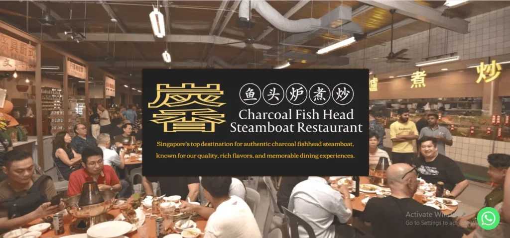 "Promotional image for Charcoal Fish Head Steamboat Restaurant, featuring a large black logo overlay in the center with gold and white text. The overlay reads 'Charcoal Fish Head Steamboat Restaurant' alongside Chinese characters and the description: 'Singapore's top destination for authentic charcoal fishhead steamboat, known for our quality, rich flavors, and memorable dining experiences.' The background shows a bustling, dimly lit indoor dining area filled with customers seated around round tables enjoying hotpot meals."