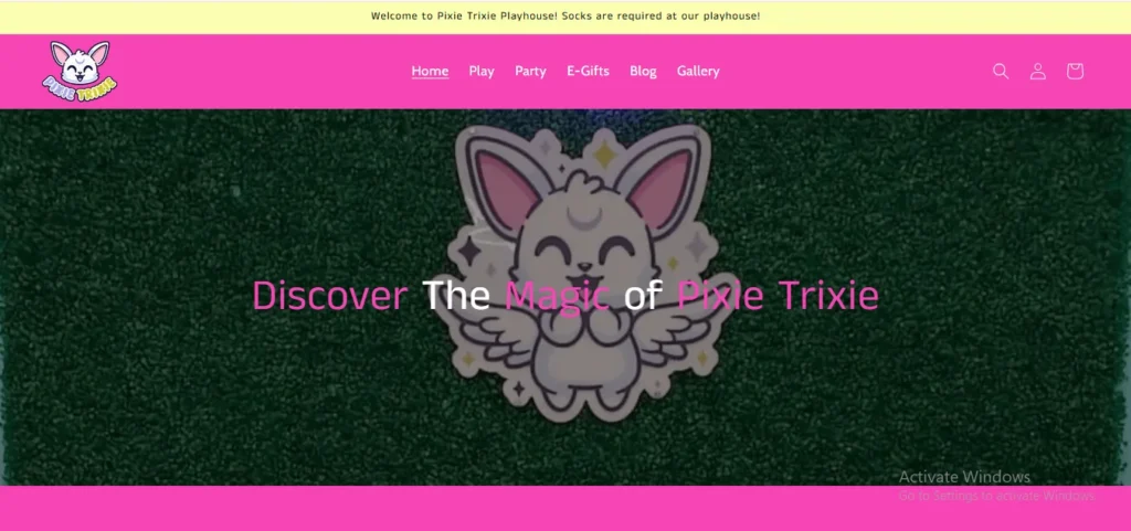 A screenshot of the Pixie Trixie website homepage featuring a bright pink navigation header with a cartoon bunny logo and menu links. Below, a green grass-textured background displays a cute, winged bunny character with the overlay text, "Discover The Magic of Pixie Trixie."