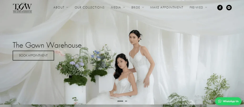 Homepage screenshot of The Gown Warehouse bridal studio website, featuring two models in elegant white wedding gowns against a draped white fabric backdrop with floral arrangements.