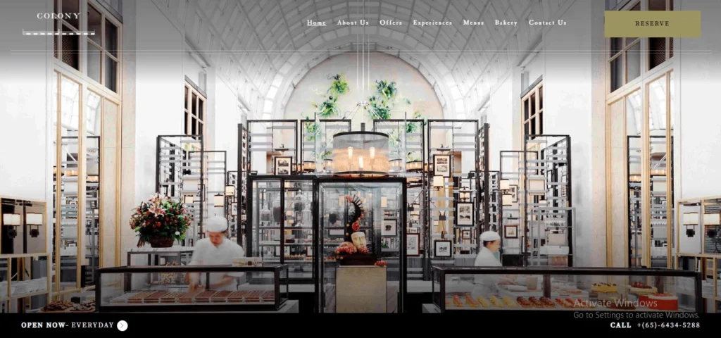 Website homepage for Colony restaurant in Singapore featuring a luxury high-ceiling interior and a premium dessert buffet counter.