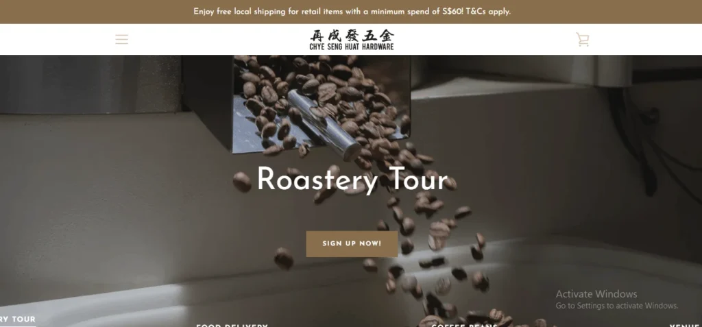 A website header for Chye Seng Huat Hardware cafe featuring a banner image of roasted coffee beans pouring from a commercial roaster, overlayed with the text "Roastery Tour" and a "SIGN UP NOW!" button.