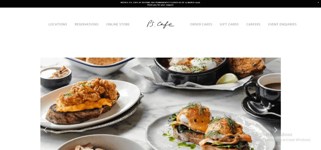 A website header for P.S. Cafe featuring a prominent handwritten-style logo and a bright, appetizing banner image displaying various brunch dishes like eggs benedict and fried chicken on toast.