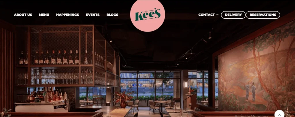 Elegant dining room interior at Kee's restaurant, showcasing contemporary decor, ambient lighting, and large windows looking out to a city street view.