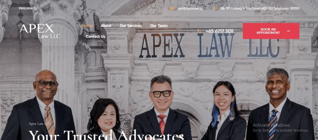 A screenshot of the Apex Law LLC website homepage, featuring a group photograph of five smiling legal professionals in formal corporate attire against a grayscale background of classical building architecture. The text "Your Trusted Advocates" is partially visible at the bottom. The website header displays the logo "APEX Law LLC" on the left, an email address (ask@apexlaw.sg) and office address (Blk 190 Lorong 6 Toa Payoh #03-512 Singapore 310190) at the top, and navigation links including Home, About, Our Services, Our Team, and Contact Us. A prominent red button on the right reads "BOOK AN APPOINTMENT" next to the firm's phone number (+65 6717 3131).