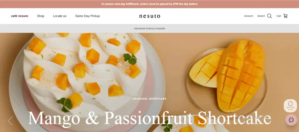 A seasonal Mango and Passionfruit Shortcake decorated with fresh diced mango, lime zest, and clear jelly, presented next to a sliced fresh mango on Nesuto cafe's website.