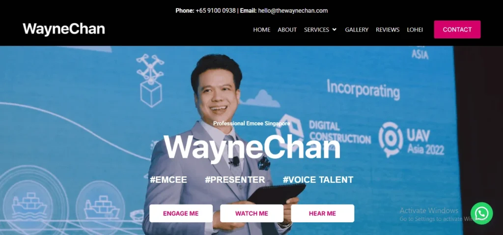 Website hero section for Wayne Chan, a professional emcee in Singapore, featuring his logo, contact details, navigation menu, and a photo of him hosting on stage against a blue event backdrop with the hashtags #EMCEE, #PRESENTER, and #VOICE TALENT.