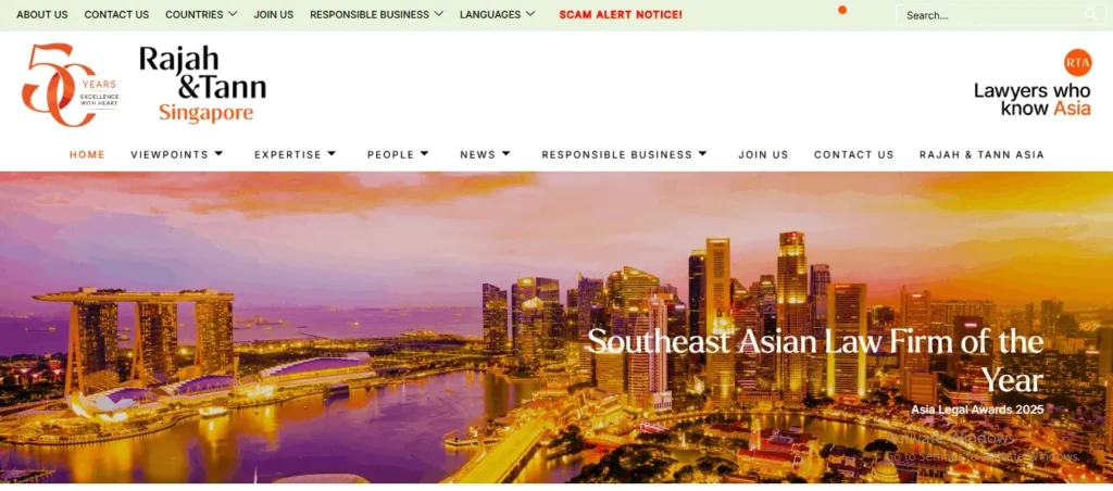 Screenshot of the homepage for "Rajah & Tann Singapore", featuring a vibrant sunset panoramic hero image of the Singapore skyline and Marina Bay Sands lit up at dusk. The top menu bar includes a 50th-anniversary logo, firm branding, search bar, red "SCAM ALERT NOTICE!" link, and main navigation links such as "HOME", "VIEWPOINTS", "EXPERTISE", "PEOPLE", "NEWS", and "CONTACT US". Large white text overlaid on the banner photo reads "Southeast Asian Law Firm of the Year" alongside the subtext "Asia Legal Awards 2025".