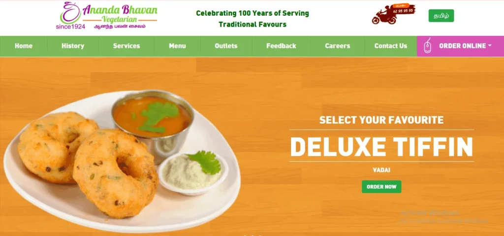 Ananda Bhavan Vegetarian website banner featuring a Deluxe Tiffin promotion with an image of crispy South Indian vadai served with chutney and sambar.