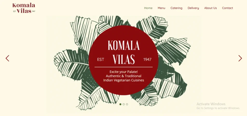 Website banner slider for Komala Vilas restaurant featuring their logo on a red circle backdrop with banana leaves, advertising authentic and traditional Indian vegetarian cuisines.