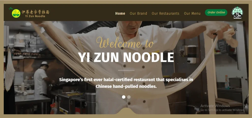 Website homepage for Yi Zun Noodle featuring a chef in a white uniform pulling long strands of fresh noodle dough in a commercial kitchen. Overlaid text reads, "Welcome to YI ZUN NOODLE. Singapore's first ever halal-certified restaurant that specialises in Chinese hand-pulled noodles."