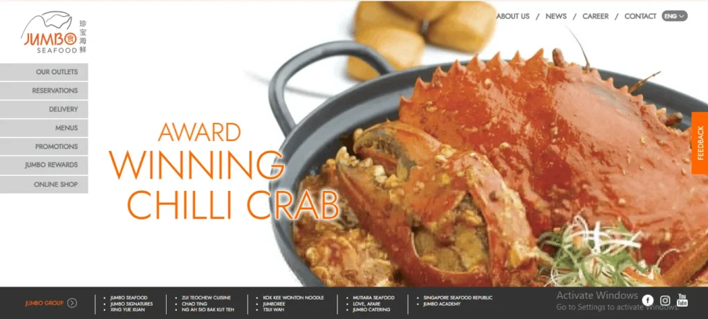 A screenshot of the Jumbo Seafood website homepage featuring a large close-up image of a vibrant red chilli crab in a black wok. Orange text overlay on the left reads "AWARD WINNING CHILLI CRAB". The top-left corner displays the "JUMBO Seafood" logo, accompanied by a vertical navigation sidebar with links like "Our Outlets," "Reservations," and "Menus." A black footer bar at the bottom lists restaurant brands under the Jumbo Group.