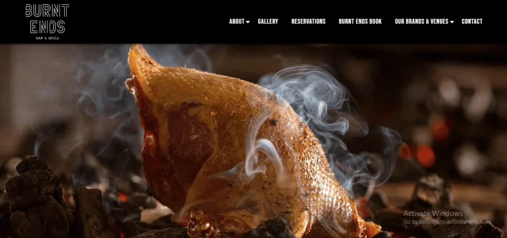 Premium meat grilling over hot coals, featured on Burnt Ends Singapore steakhouse website.